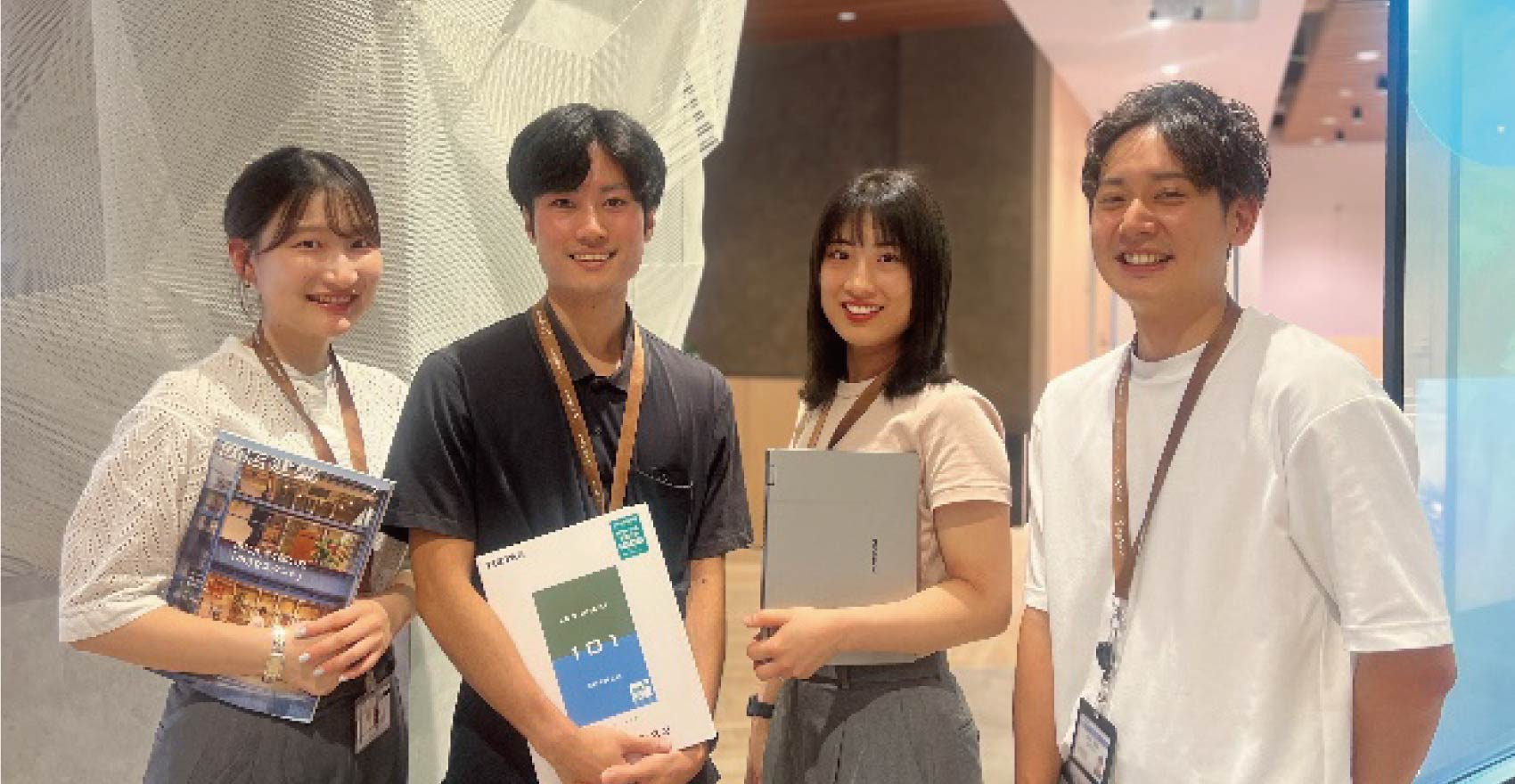 男性社員2名と女性社員2名が正面を向いて並んで笑顔をむける様子