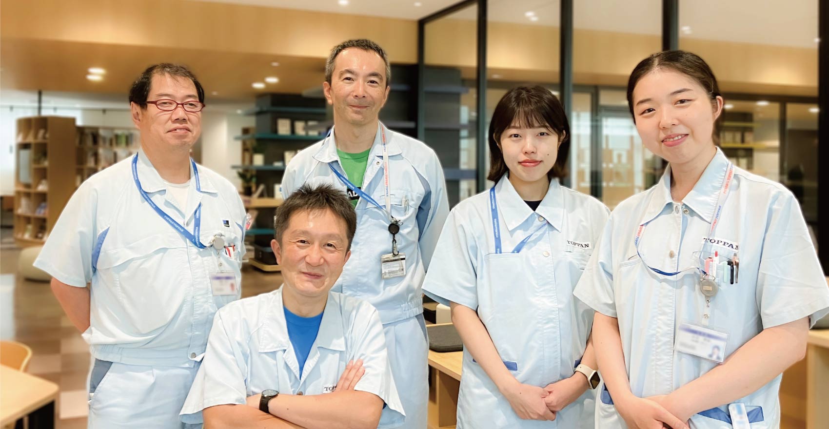 男性社員3名と女性社員2名が正面を向いて並んで笑顔をむける様子