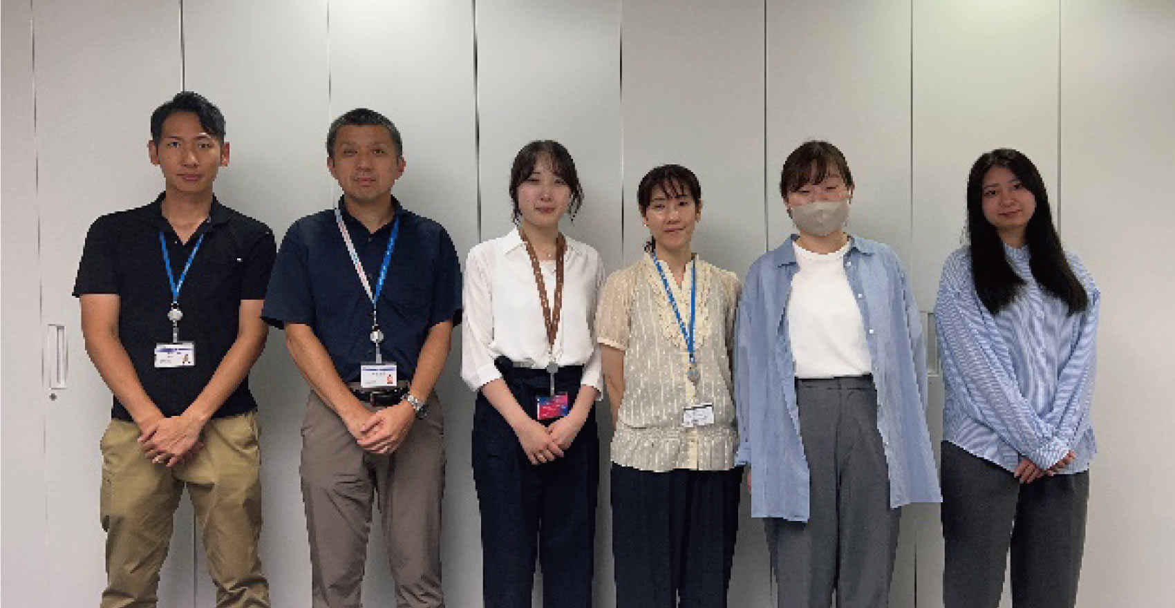 男性社員2名と女性社員4名が正面を向いて並んで笑顔をむける様子